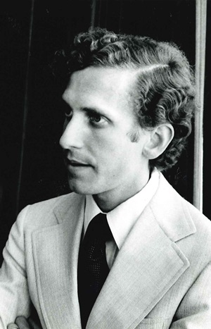 A black and white photo of John H. Glick, MD, shown in profile as a young man in the 1970s.